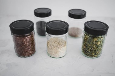 Basit gıda malzemeleri konsepti, susamlı haşhaş köpük chia ve keten tohumları içeren tohumlar beyaz arka planda önemli besin kaynakları olarak kullanılıyor.