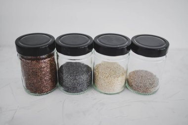 Basit gıda malzemeleri konsepti, susamlı haşhaş köpük chia ve keten tohumları içeren tohumlar beyaz arka planda önemli besin kaynakları olarak kullanılıyor.