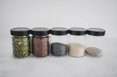 Basit gıda malzemeleri konsepti, susamlı haşhaş köpük chia ve keten tohumları içeren tohumlar beyaz arka planda önemli besin kaynakları olarak kullanılıyor.