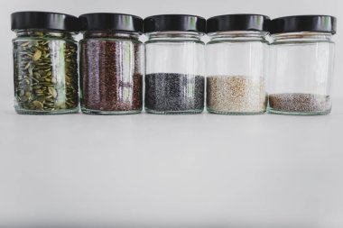 Basit gıda malzemeleri konsepti, susamlı haşhaş köpük chia ve keten tohumları içeren tohumlar beyaz arka planda önemli besin kaynakları olarak kullanılıyor.