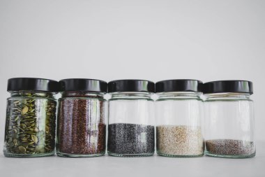 Basit gıda malzemeleri konsepti, susamlı haşhaş köpük chia ve keten tohumları içeren tohumlar beyaz arka planda önemli besin kaynakları olarak kullanılıyor.