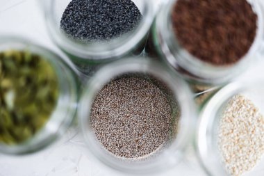 Basit gıda malzemeleri konsepti, susamlı haşhaş köpük chia ve keten tohumları içeren tohumlar beyaz arka planda önemli besin kaynakları olarak kullanılıyor.