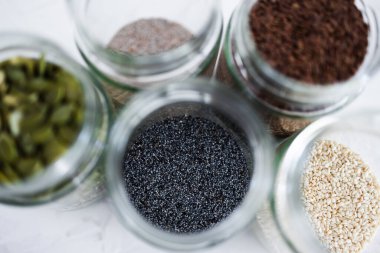 Basit gıda malzemeleri konsepti, susamlı haşhaş köpük chia ve keten tohumları içeren tohumlar beyaz arka planda önemli besin kaynakları olarak kullanılıyor.