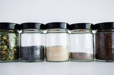 Basit gıda malzemeleri konsepti, susamlı haşhaş köpük chia ve keten tohumları içeren tohumlar beyaz arka planda önemli besin kaynakları olarak kullanılıyor.