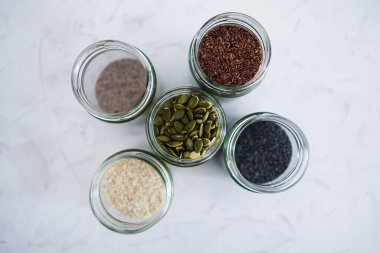 Basit gıda malzemeleri konsepti, susamlı haşhaş köpük chia ve keten tohumları içeren tohumlar beyaz arka planda önemli besin kaynakları olarak kullanılıyor.