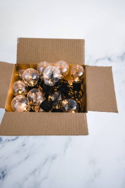 Kutu konseptinin dışında düşünme ve düşünme, açık bir kutudan parlayan bir grup ampul.