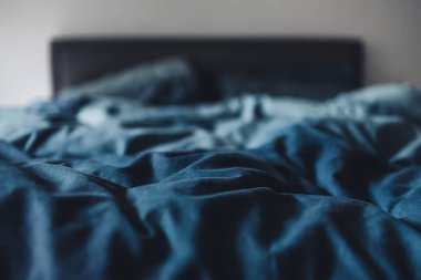 dağınık kraliçe yatağı mavi yorgan örtüsü ve buruşuk çarşaflar, uyku konsepti ya da çift hayatı