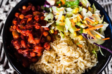 sağlıklı bitkisel yemek tarifleri, fasulye soslu vegan besin kasesi, pirinç ve Meksika lahana salatası karışımı.