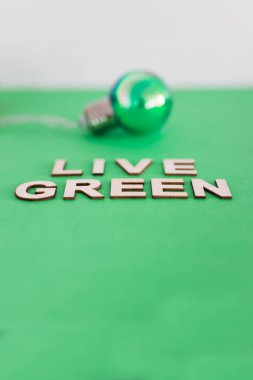 ekoloji ve sürdürülebilirlik, yeşil ampul üzerinde canlı yeşil metin ton arkaplanı üzerine 