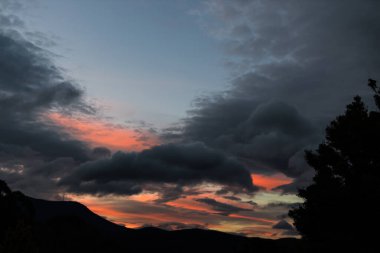 Günbatımı, Tazmanya, Avustralya 'da dağlar ve yoğun bitki örtüsü ile cennet bahçeleri üzerinde.