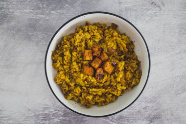 Sebzeli mercimek pilavı ve terbiye edilmiş tofu küpleri ve sağlıklı bitki bazlı yemek tarifleriyle kaplı Çin baharatları.