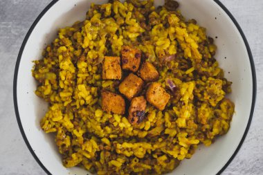 Sebzeli mercimek pilavı ve terbiye edilmiş tofu küpleri ve sağlıklı bitki bazlı yemek tarifleriyle kaplı Çin baharatları.