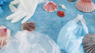 Mavi arkaplan üzerindeki okyanus metnini deniz kabukları ve çevresel kirliliğin düzeltilmesi, ekoloji ve gezegene olan saygının plastik çöp sembolüyle kaydet