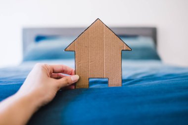 Ev ikonu, odak dışı kral yatağının önünde mavi yatak odası, ev arama, ev dekorasyonu ya da evlilik hayatı kavramsal imajı olan çiftlerin yatak odasında.