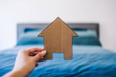 Ev ikonu, odak dışı kral yatağının önünde mavi yatak odası, ev arama, ev dekorasyonu ya da evlilik hayatı kavramsal imajı olan çiftlerin yatak odasında.