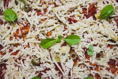 Ev yapımı vejetaryen pizzalar mutfak tezgahında hazırlanıyor, sağlıklı bitki temelli yemek tarifleri.