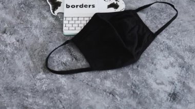 Üzerinde yüz maskesi olan dünya haritası. Sınır çizgileri, metin ve seyahat sanayisi.