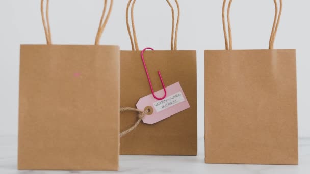 妇女拥有的购物袋上的商业标签 周围都是竞争对手的购物袋 支持平等 — 图库视频影像