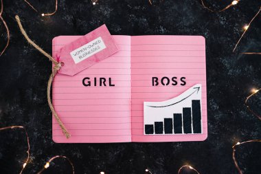 Pembe not defteri ile ilgili kız patron metni ve yanında pozitif büyüme istatistikleri olan iş yerleri sahibi kadınlar, kadın girişimciler için eşitlik ve iş büyümesini destekliyor