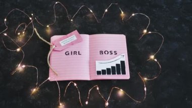 Pembe not defteri üzerine kız patron metni ve yanında pozitif büyüme istatistikleri olan iş yerleri sahibi kadınlar, eşitlik ve iş büyümesini destekliyor.