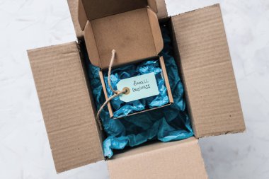 Daha büyük bir paketin içinde küçük işletme metninin yer aldığı ürün etiketi, müşteri davranışları konsepti ve küçük yerel işletmeleri destekleme