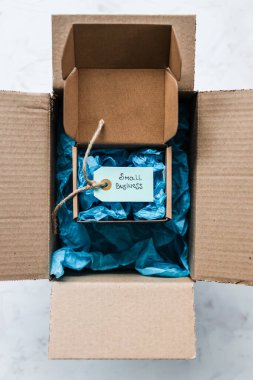 Daha büyük bir paketin içinde küçük işletme metninin yer aldığı ürün etiketi, müşteri davranışları konsepti ve küçük yerel işletmeleri destekleme
