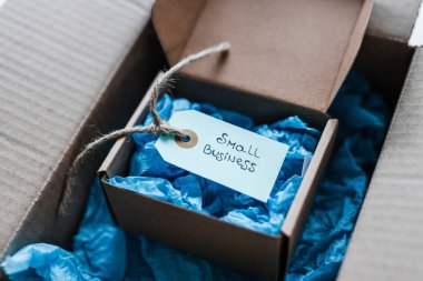 Daha büyük bir paketin içinde küçük işletme metninin yer aldığı ürün etiketi, müşteri davranışları konsepti ve küçük yerel işletmeleri destekleme