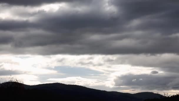 オーストラリアのタスマニアで冬に撮影された山と厚い植生を覆う雲と強い太陽の光がピークを迎える嵐の空の時間の経過 — ストック動画