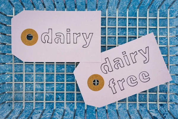 dairy vs dairy-free product tags with shopping basket, concept of plant-based food or allergies and nutritional choices