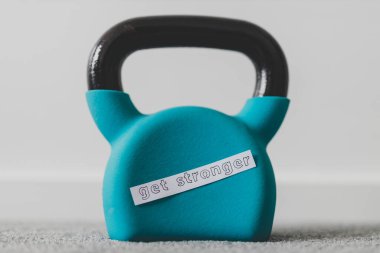 Evde spor salonu ve boş zamanlarınızda kavramsal görüntüde egzersiz yapmak, yerde kettlebell ve daha güçlü bir mesaj. 