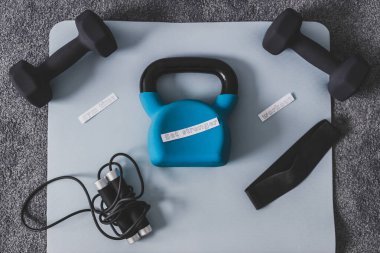 Boş zamanlarınızda beden eğitimi, kavramsal görüntüde egzersiz, halterli kettlebell ve yatak odasındaki yoga minderinde rop atlama, daha güçlü bir mesaj. 