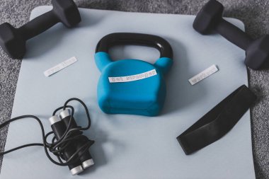 Boş zamanlarınızda beden eğitimi, kavramsal görüntüde egzersiz, halterli kettlebell ve yatak odasındaki yoga minderinde rop atlama, daha güçlü bir mesaj. 