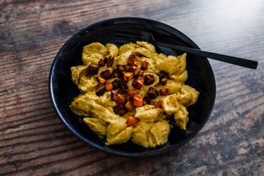 Vejetaryen kremalı balkabaklı makarna üzerine kavrulmuş kabak küpü, sağlıklı bitki bazlı yemek tarifleri.