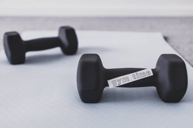 Evde spor salonu, boş zamanlarınızda egzersiz, yatak odasındaki yoga minderinde halter, daha güçlü spor yap ve spor salonuna git mesajları.