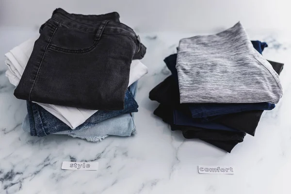 スタイル対コンフォートカテゴリーに分類されているジーンズとパンツの山 脱穀の概念と良い見た目や気分を優先 — ストック写真