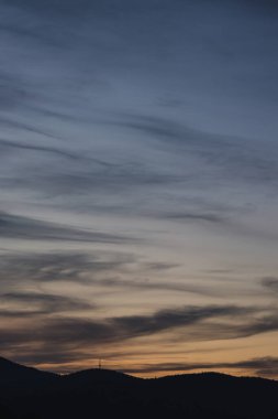 Tazmanya, Avustralya 'da kışın çekilen pembe ve turuncu bulutlarla gün batımı gökyüzü