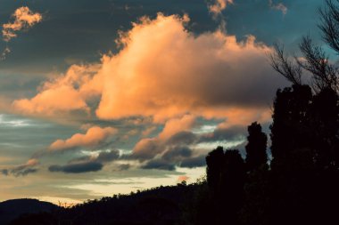 Tazmanya, Avustralya 'da kışın çekilen pembe ve turuncu bulutlarla gün batımı gökyüzü