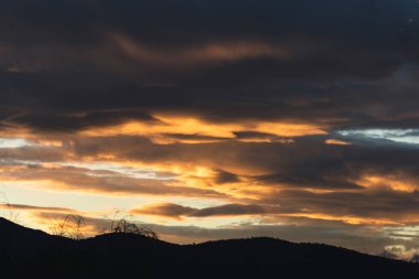 Tazmanya, Avustralya 'da kışın çekilen pembe ve turuncu bulutlarla gün batımı gökyüzü