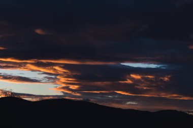 Tazmanya, Avustralya 'da kışın çekilen pembe ve turuncu bulutlarla gün batımı gökyüzü
