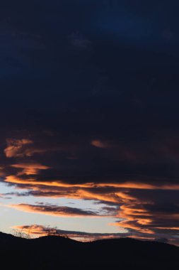 Tazmanya, Avustralya 'da kışın çekilen pembe ve turuncu bulutlarla gün batımı gökyüzü