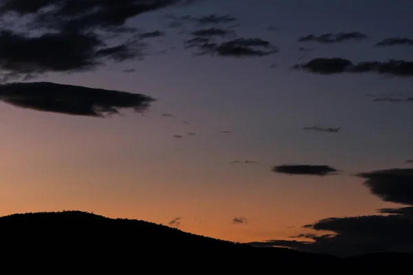 sunset sky with purple and orange tones over the mountains shot in Tasmania, Australia in winter