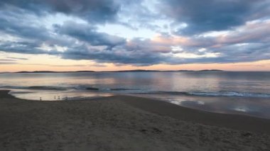 sunset on pristine beach in Southern Tasmania in Australia with colorful clouds reflecting over the Pacific Ocean and no people, shot in winter