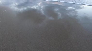 sunset on pristine beach in Southern Tasmania in Australia with colorful clouds reflecting over the Pacific Ocean and no people, shot in winter