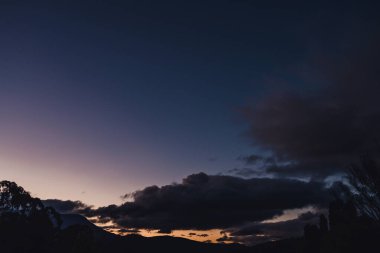 Kış günbatımında dağların üzerinde yoğun renkler ve Tazmanya, Avustralya 'da yoğun bitki örtüsü.