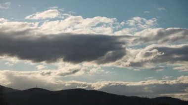 Günün zamanı geçiyor ve bulutlar dağların üzerinden yuvarlanıyor ve Tazmanya, Avustralya 'da yoğun bitki örtüsü vuruyor.