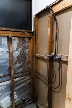 Duş duvarları, iç kısımları açıkta ve bakır borular, ev yenileme ve esnaf işleri kavramı ile duş yenileme