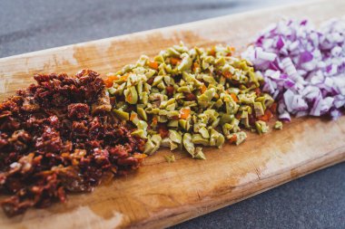 Kurutulmuş soğan domatesleri ve doğranmış doğranmış ve doğranmış tahtalar bir tarifte kullanılmaya hazır, basit, sağlıklı malzemeler konsepti.