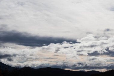 Parlak beyaz ve zıt bulutlar kışın fırtınalı bir gökyüzüne gelip gidiyorlar.