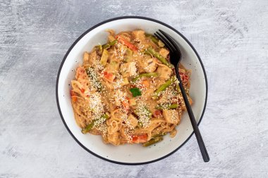 Fıstık ezmesi soslu vegan Thai stiry kızartması ve susam tohumlu vermicelli şehriye, sağlıklı bitki temelli yemek tarifleri.