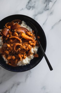 Nohut soğanlı vegan chana masala sosu ve beyaz pirinç, sağlıklı bitki temelli yemek tarifleri.